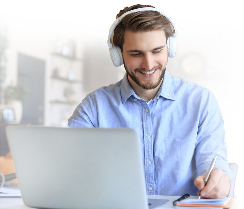 Person smiling sitting at a desk on their laptop