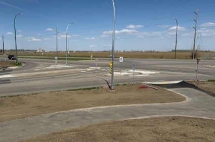 Integrally coloured concrete pathway along Parkside Drive South maintaining visual continuity with the trail network while providing improved durability at urban transitions.